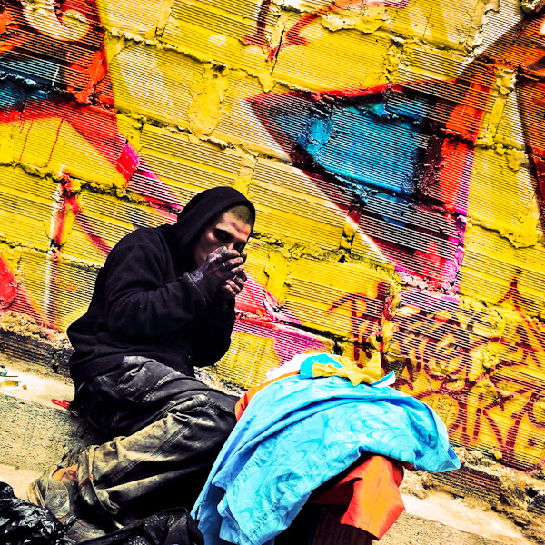 A Colombian drug addict smokes ‘bazuco’ (raw cocaine paste) in front the wall, covered in graffiti artwork in the center of Bogotá, Colombia.