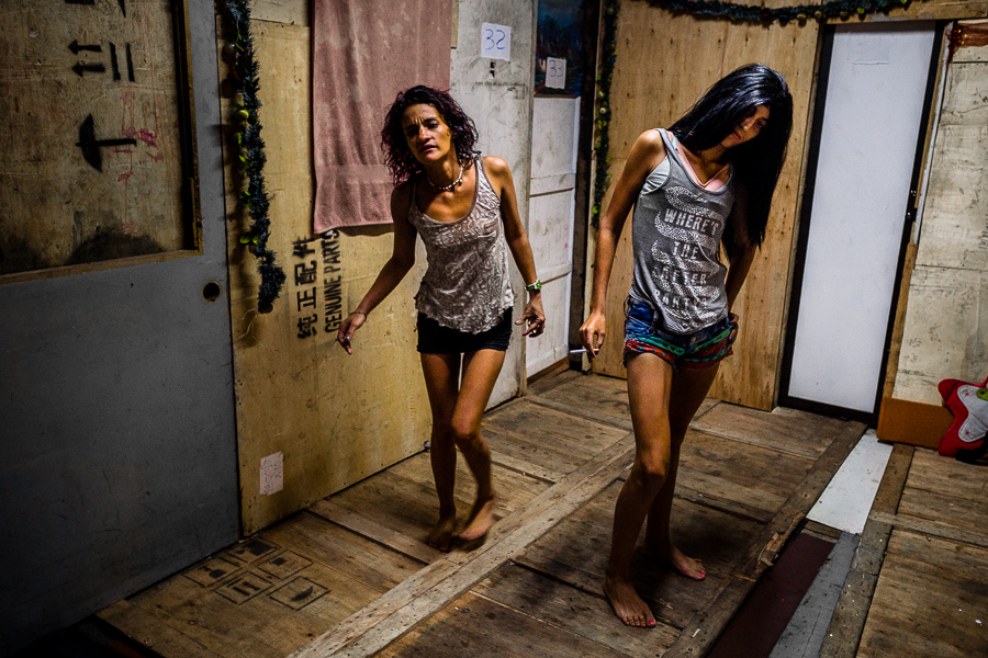 Colombian drug addicts pass between built-in rooms constructed inside a house in “El Bronx”, a drug distribution area in Medellín, Colombia.