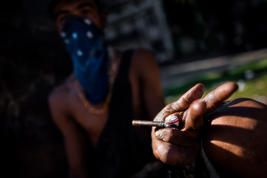 A Colombian drug consumer holds a pipe loaded by ‘bazuco’ (a raw cocaine paste) while smoking it on the street of Medellín, Colombia.