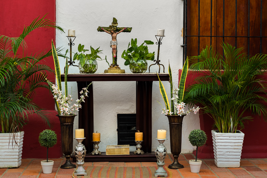 An ornate tabletop crucifix is seen placed beside plants and candlesticks on a street altar during the Holy Week celebrations in Mompox, Colombia.