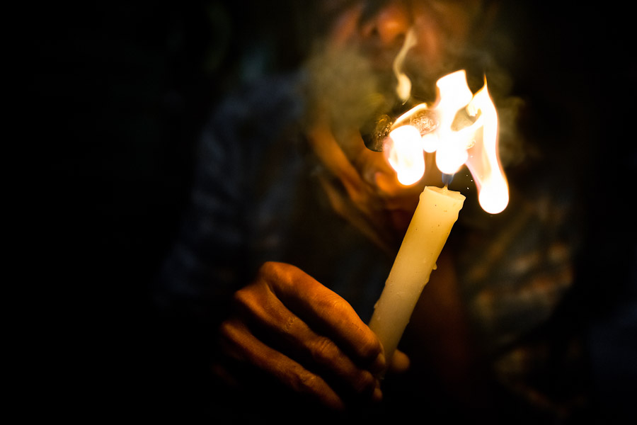 A Colombian urban shaman (brujo) lights up three cigars to devine the future from burn tobacco leaves in his house in Cali, Colombia.