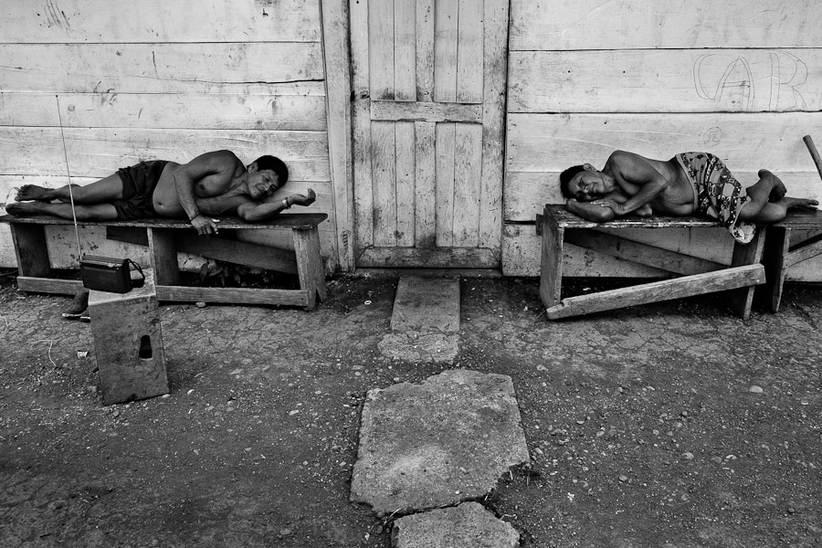 A husband and wife listen to the radio while relaxing on the benches in Unión Chocó, an Emberá indigenous community in Darién, Panama.