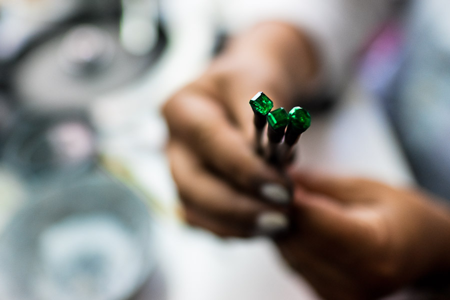 An emerald cutter shows a gemstone she is working on in a cutting and polishing workshop in Bogota, Colombia.