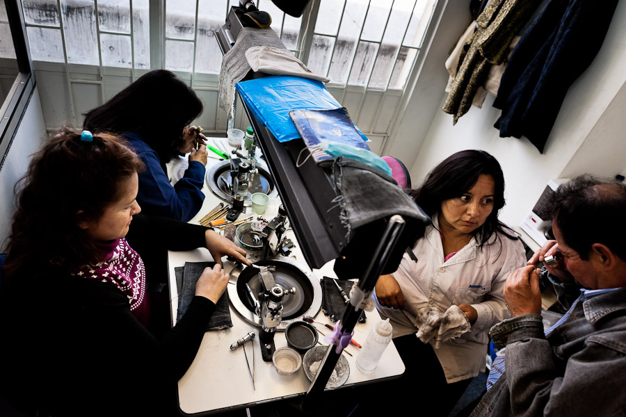 An emerald owner checks out a processed gemstone in a cutting and polishing workshop in Bogota, Colombia.