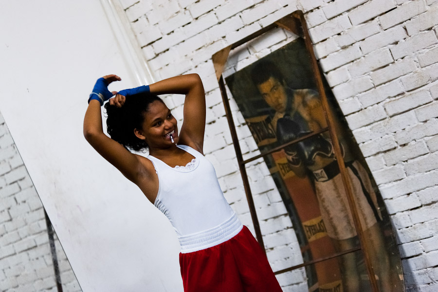 A young Colombian boxer ties hair into a ponytail before a sparring session in the boxing gym in Cali, Colombia.