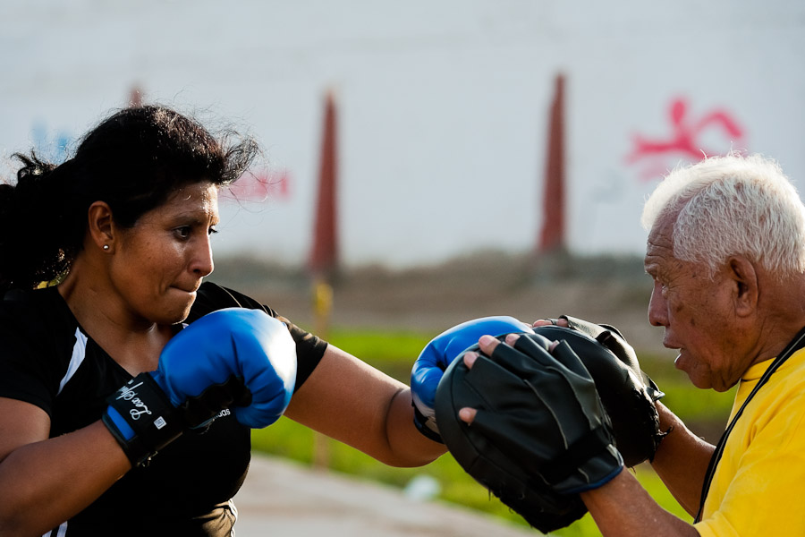 A Peruvian woman practices sparring with her coach in the outdoor boxing school at the Telmo Carbajo stadium in Callao, Peru.