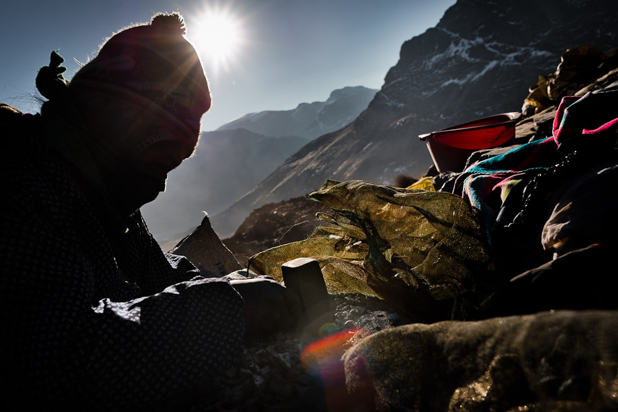 Pallaquera, a female gold miner, searches for gold on a load of waste rock from the gold mines in La Rinconada, Peru.