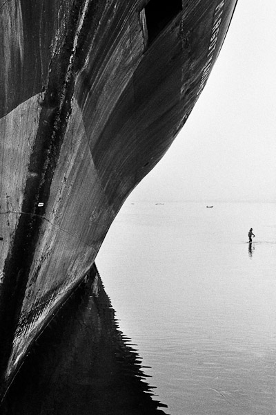 A Chilean fisherman fishes with a net in the shallow water close to a shipwreck in the port of Coquimbo, Chile.