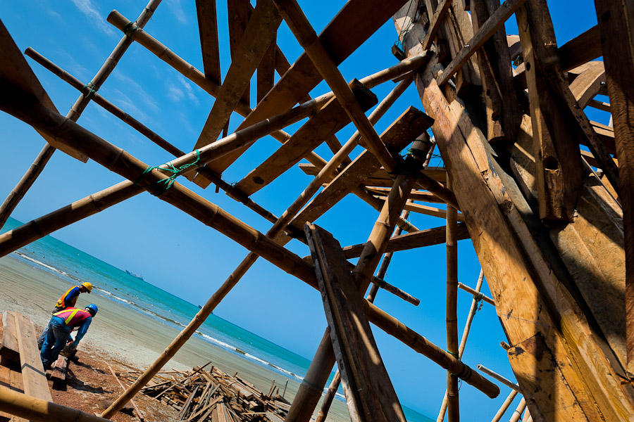 Ecuadorian shipbuilding workers build a traditional wooden fishing vessel in an artisanal shipyard on the beach in Manta, Ecuador.