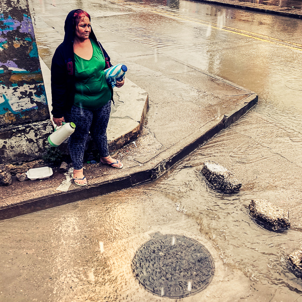 A Colombian coffee vendor crosses a street flash flooded by a heavy rain storm during the annual rainy season in Cartagena, Colombia.