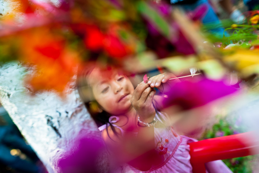 A Salvadoran girl decorates coconut palm fronds with flower blooms during the Flower & Palm Festival in Panchimalco, El Salvador.