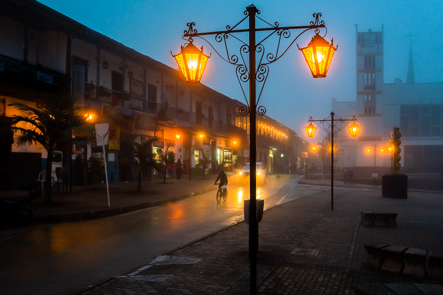 Street lamps are seen shining in the plaza during the foggy nightfall in Sonsón, a village in the coffee region (Zona cafetera) of Colombia.