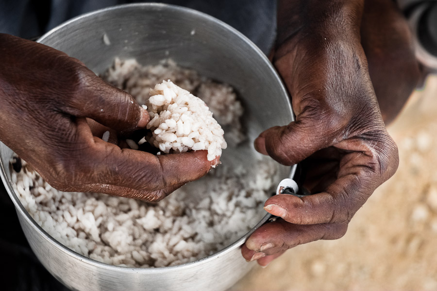 An Haitian woman eats rice in the slum of Cité Soleil, Port-au-Prince, Haiti.