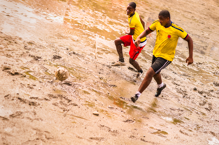 Afro-Colombian boys play football during the training session on a dirt field in Quibdó, Chocó, Colombia.