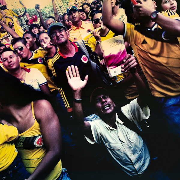 A Colombian man, holding a bible in his hand, prays while watching the football match between Colombia and Uruguay at the FIFA World Cup 2014, in a park in Cali, Colombia.