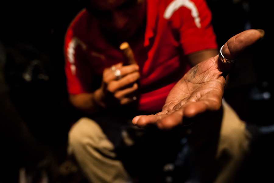 A Salvadorean ‘brujo’ (sorcerer) stretches out his hand towards the client before starting the tobacco reading ritual in a street fortune telling shop in San Salvador, El Salvador.