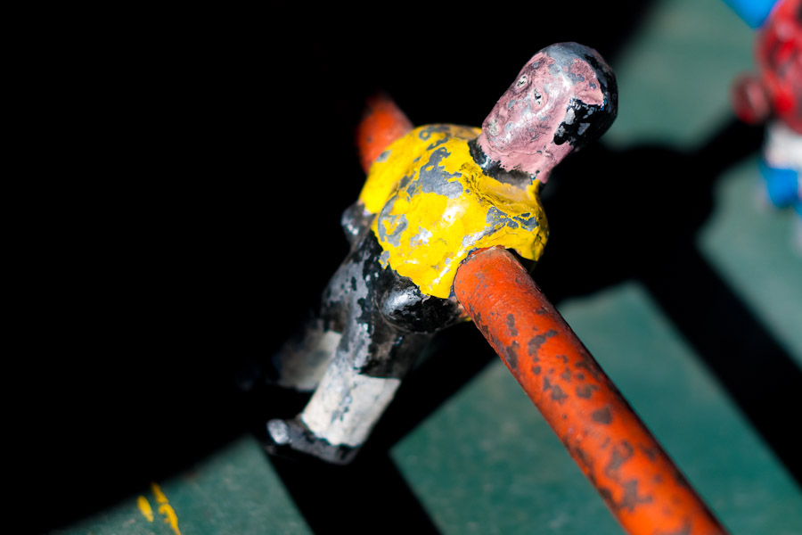 Table football player in yellow shirt, with peeled surface.