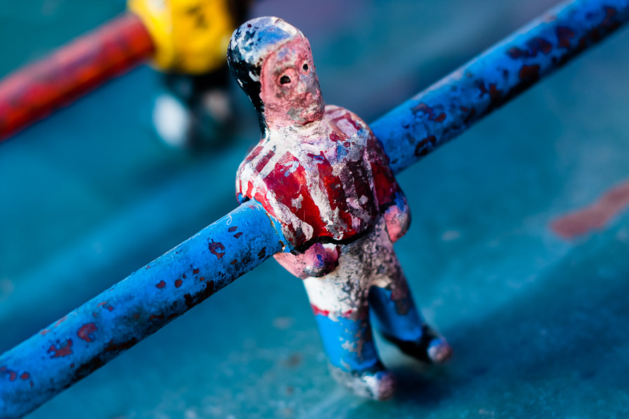 Table football player in red and white shirt, with peeled surface.