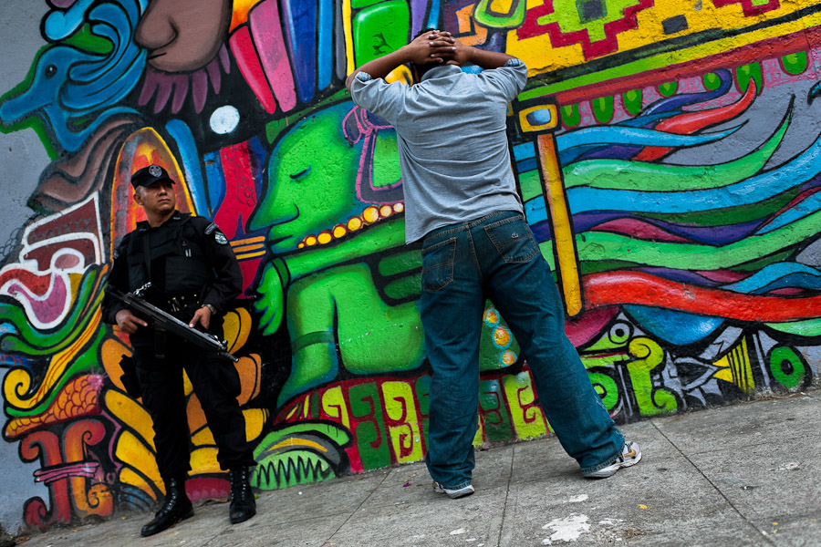 An alleged gang member is controlled by a policeman from the special emergency unit (Halcones) on the street in San Salvador, El Salvador.