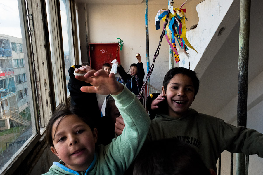 Gipsy kids, having the Easter eggs in their hands, happily dance in an apartment block.