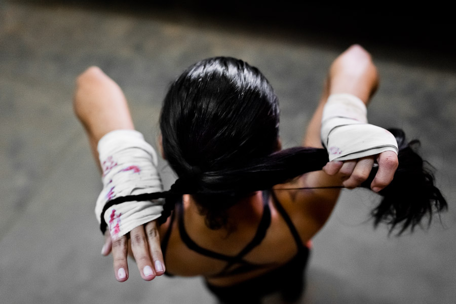Geraldin Hamann, a young Colombian boxer, ties hair into a ponytail before a workout in the boxing gym in Cali, Colombia.