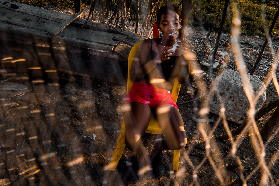 An Afro-Colombian girl is seen sitting behind a fishing net in front of a fisherman’s house in a low social class neighborhood in Cartagena, Colombia.