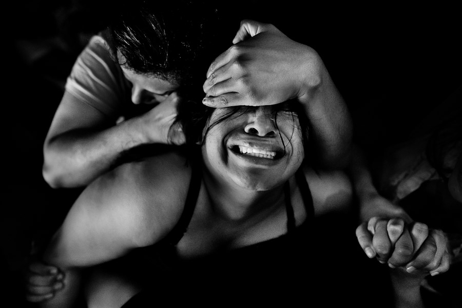 A Colombian girl, held by her fellow believers, cries while being allegedly possessed by demons during the exorcism ritual performed at a house church in Bogota, Colombia.