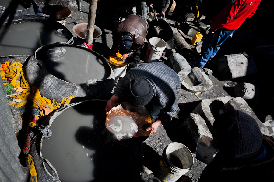 Miners separate gold from finely ground rock, using mercury and a pan, during the artisanal processing of gold ore in La Rinconada, Peru.