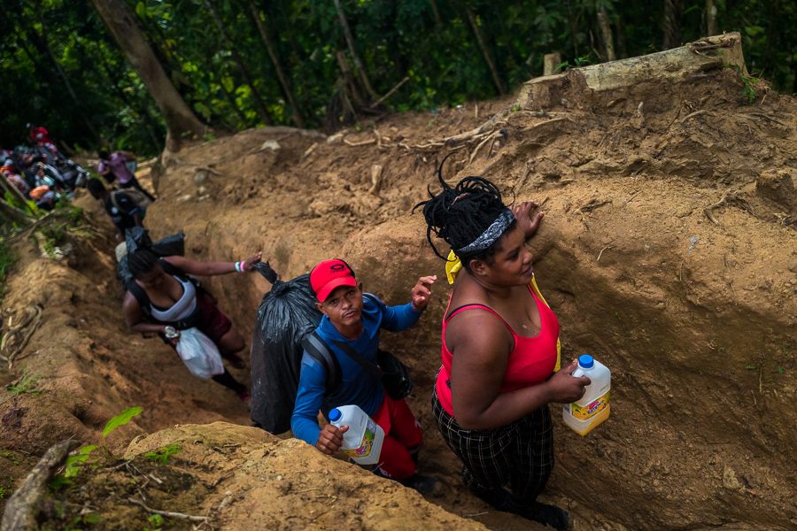 Migrants from Haiti walk through a narrow trail in the wild and dangerous jungle of the Darién Gap between Colombia and Panamá.