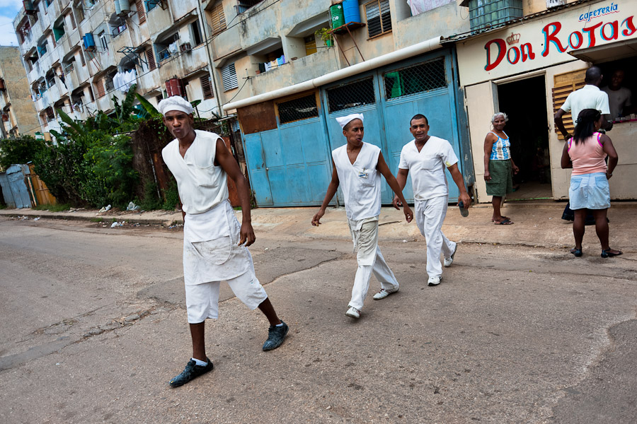 Cuban cooks walk out of the cafeteria in an apartment block in Alamar, a public housing periphery of Havana, Cuba.