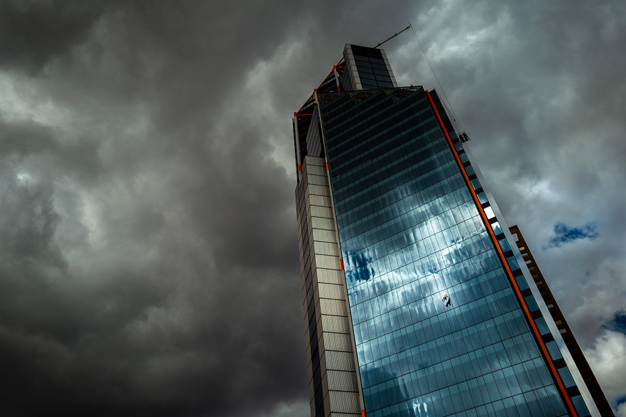 A Colombian window cleaner works outside the Atrio North Tower building before the rainstorm in Bogotá, Colombia.