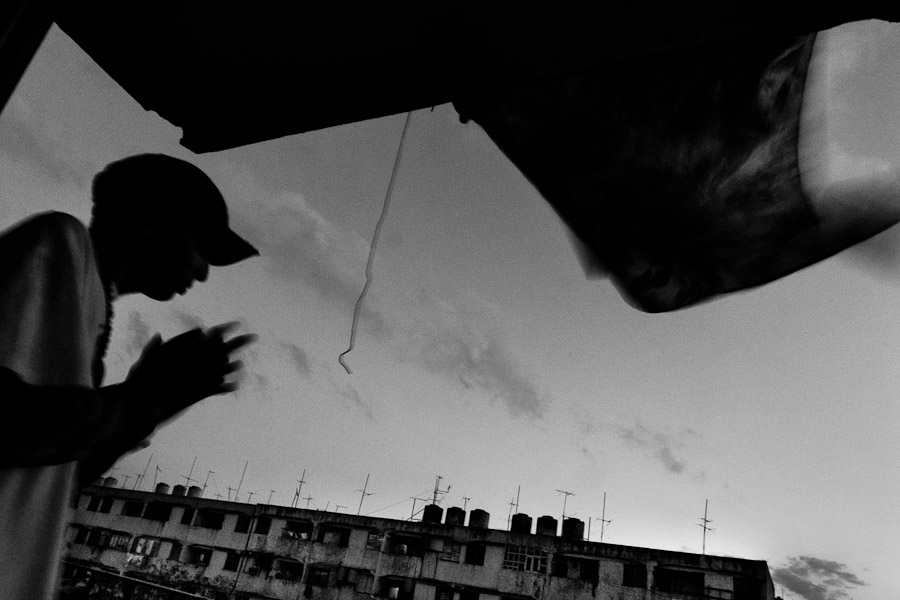Yuri C., a Cuban hip-hop fan and musician, smokes a cigarette on the balcony in the apartment block of Alamar, a public housing periphery of Havana, Cuba.