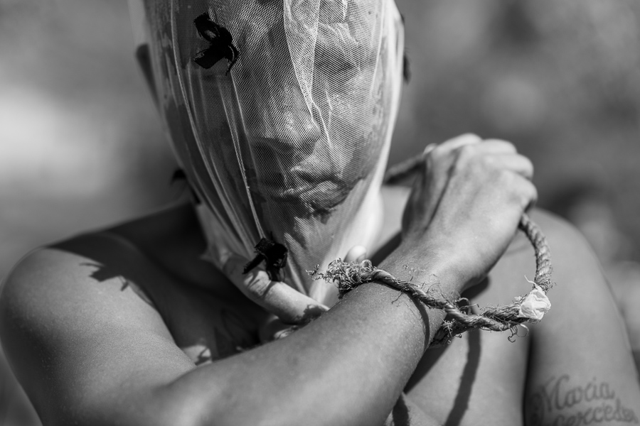 An Afro-Colombian man with his face covered by a veil whips himself as part of a self-punishment ritual during the Holy Week religious procession in Santo Tomás, Colombia.