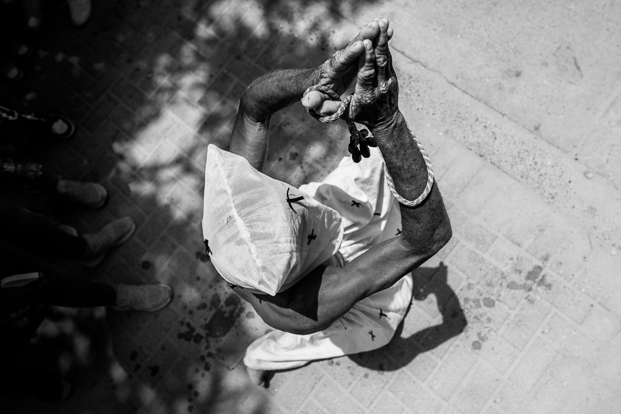 An Afro-Colombian man kneels while praying as part of the Holy Week religious procession in Santo Tomás, Colombia.