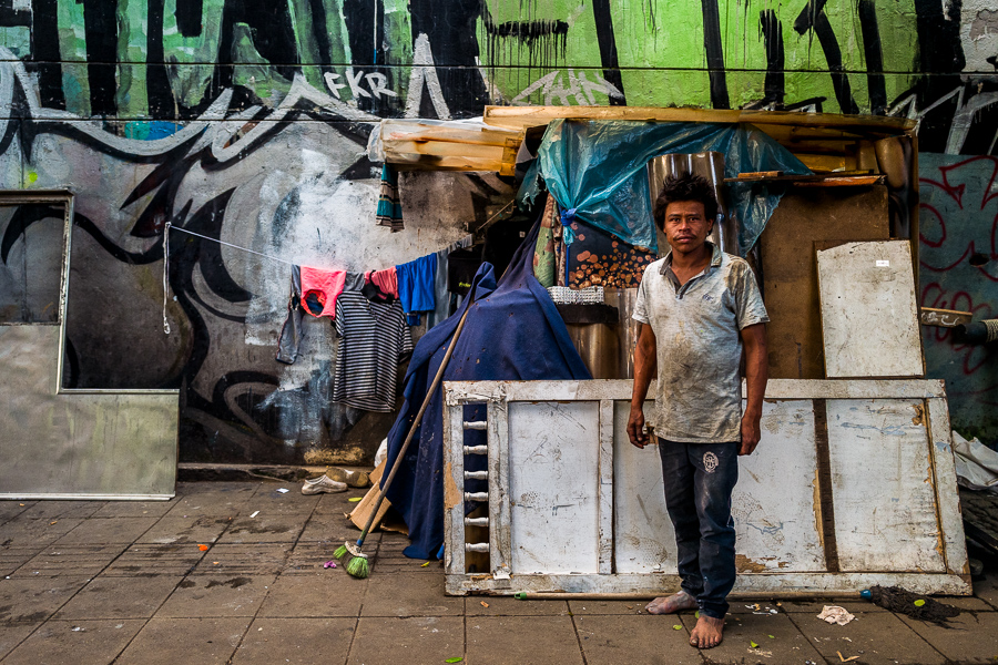 An Afro-Colombian homeless man poses for a picture in front of his improvised shelter built in the street in Medellín, Colombia.