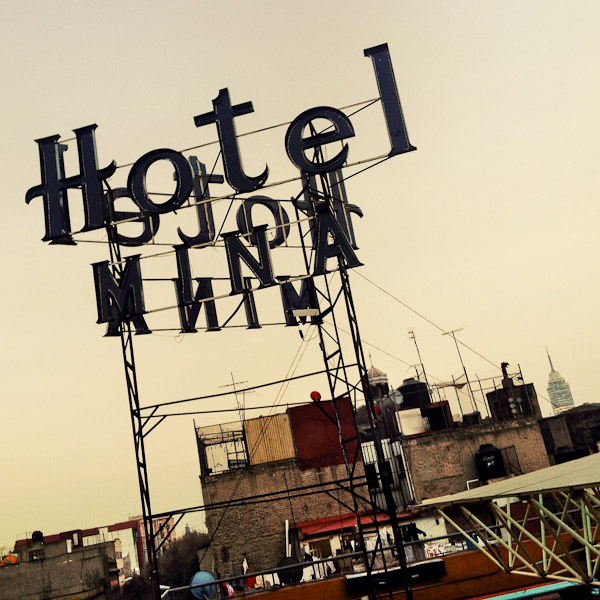 A turned off neon sign is seen on the roof of a low-budget hotel during the dusk in Mexico City, Mexico.