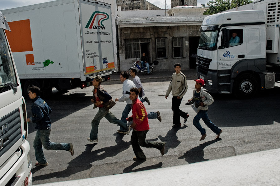 Immigrants running to escape the Moroccan police. Port authorities are checking the trucks but Harraga always find a new trick.