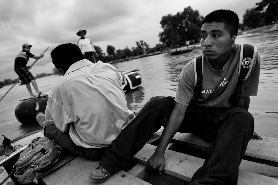 A Central America immigrant, sitting on a inner tube raft, crosses the Suchiate river from Tecún Umán, Guatemala, to Mexico.