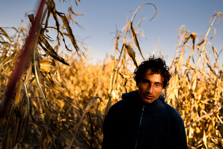 A Salvadoran immigrant waits near the railroad track to climb up the cargo train passing through the train station in Huehuetoca, Mexico.