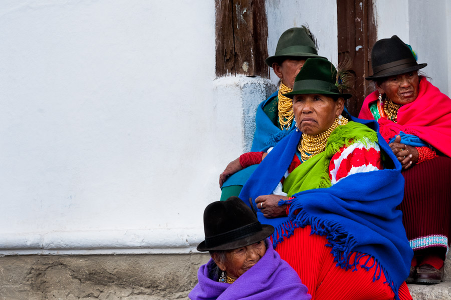 Old Indian women keep tradition of Inti Raymi festival and watch a procession passing through a mountain village.