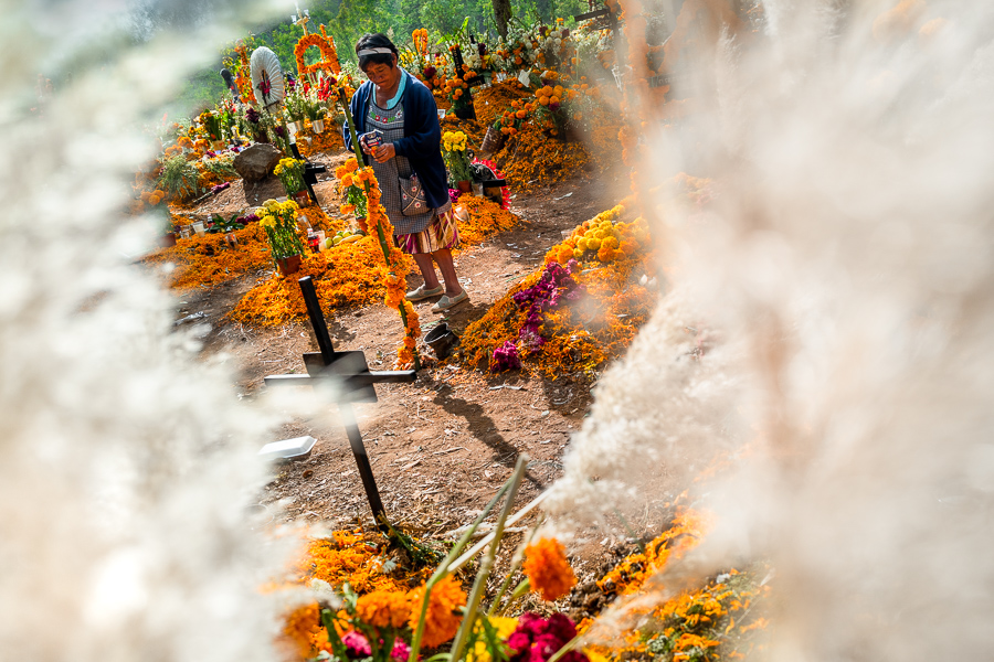 A Purepecha indigenous woman walks amongst the graves at a cemetery during the Day of the Dead celebrations in Tzurumútaro, Michoacán, Mexico.