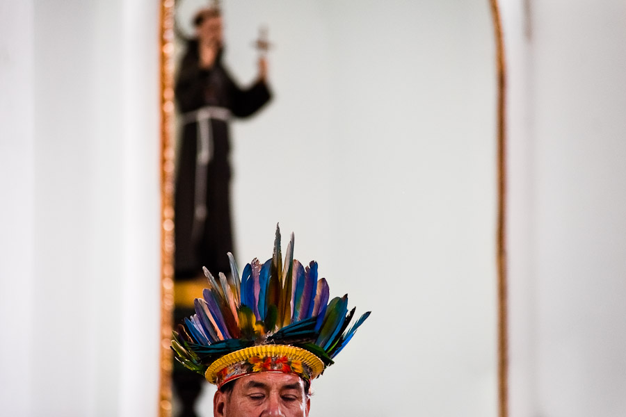 A native from the Kamentsá tribe, wearing a colorful feather headgear, participates in the Catholic mass during the Carnival of Forgiveness, a traditional indigenous celebration in Sibundoy, Colombia.