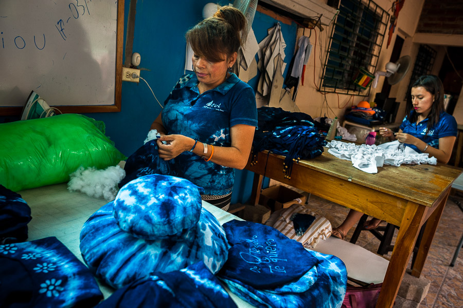 A Salvadoran woman stuffs a decorative pillow, dyed with a natural blue indigo, in an artisanal clothing workshop in Santiago Nonualco, El Salvador.