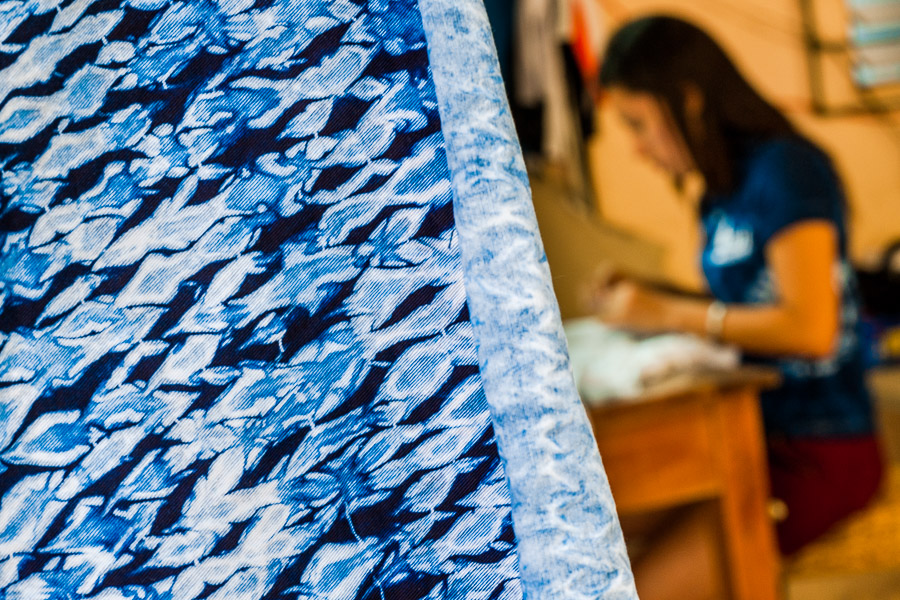 An indigo-dyed fabric is seen hung in front of a seamstress working in an artisanal clothing workshop in Santiago Nonualco, El Salvador.