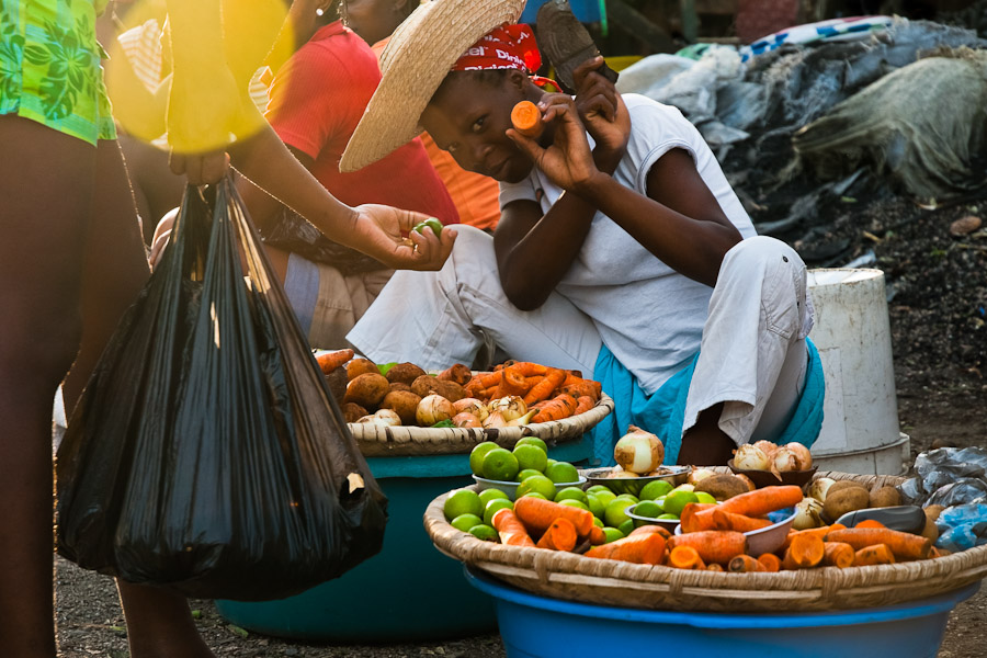 A Haitian woman sells vegetables on the street market in Port-au-Prince, Haiti.