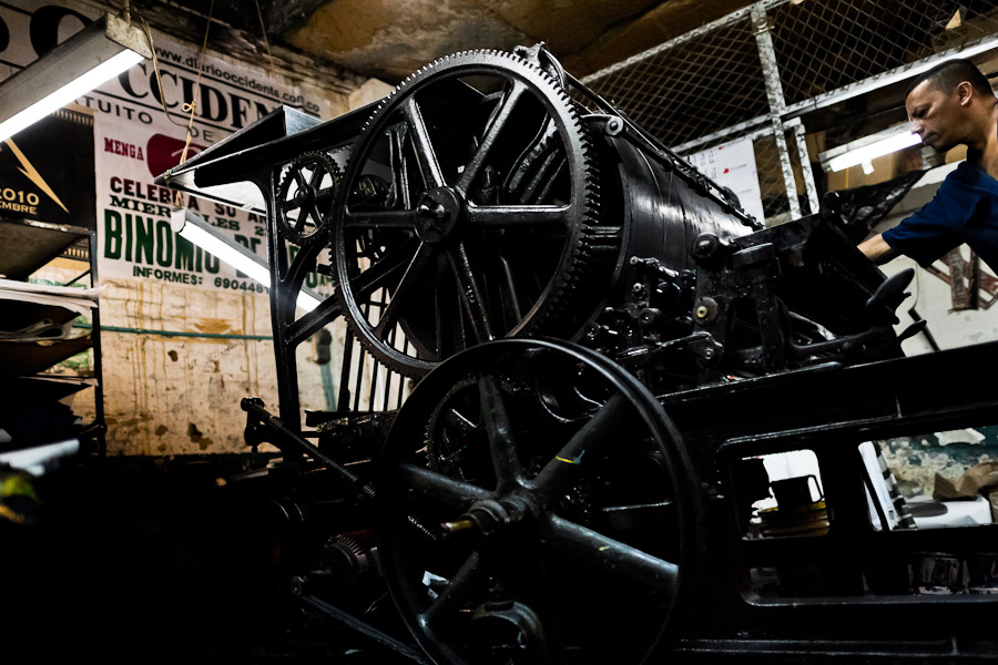 A Colombian master printer works on the ancient letterpress machine in the print shop in Cali, Colombia.