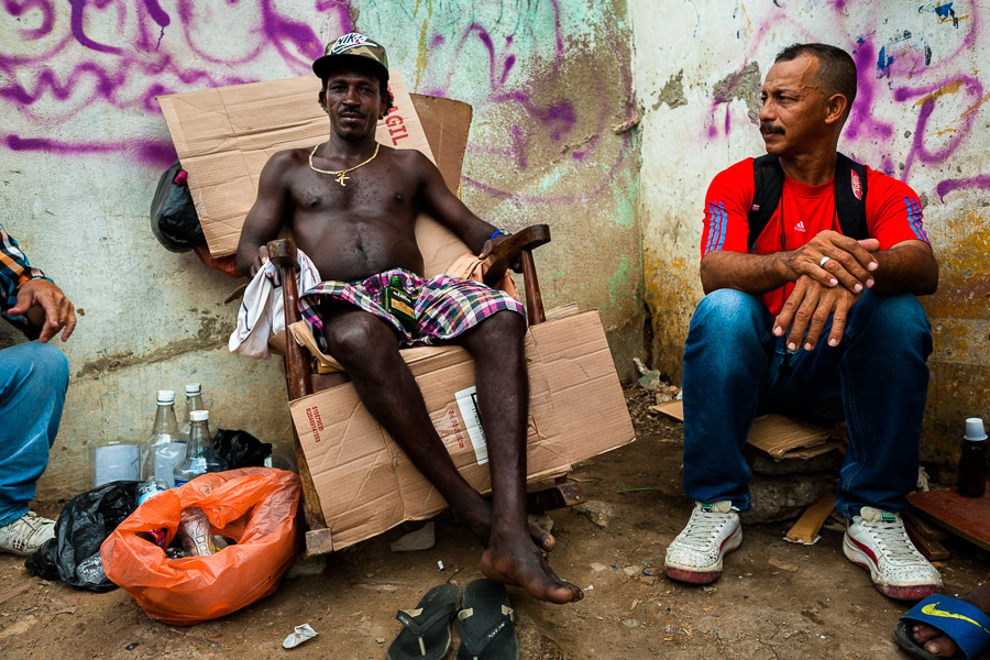 An Afro-Colombian man resells liquor from large bottles into flasks in the market of Bazurto in Cartagena, Colombia.