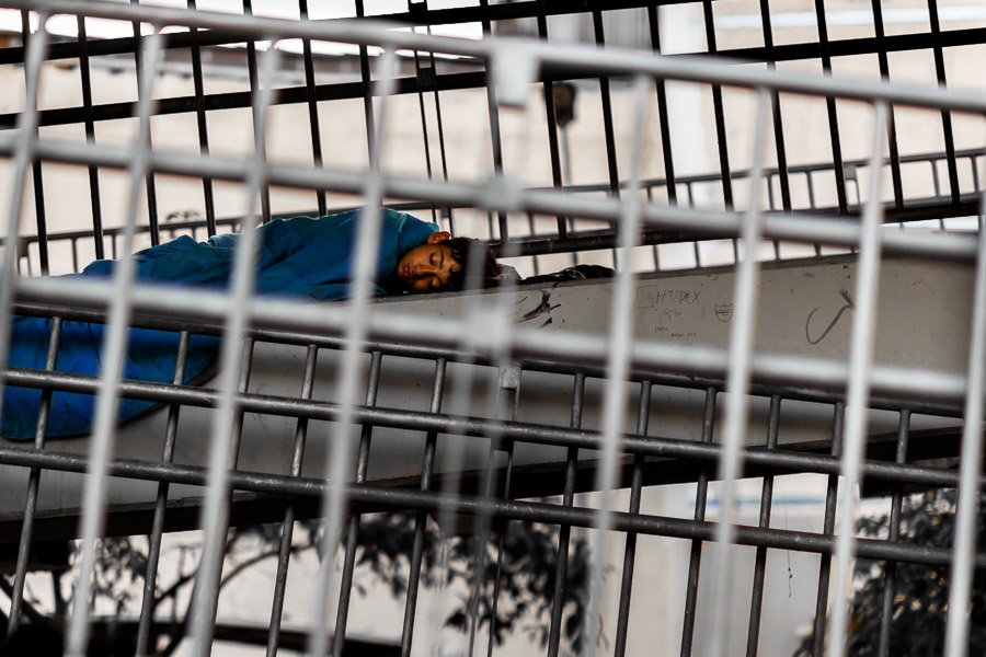 A Colombian boy, living on the street, sleeps under the pedestrian footbridge in the center of Medellín, Colombia.