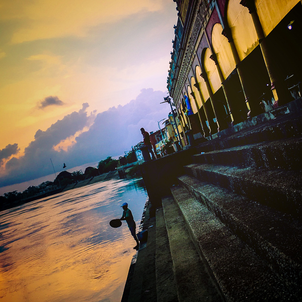 A Colombian cook washes a pot lid in the river Sinú in front of the Mercado Público in Santa Cruz de Lorica, Colombia.