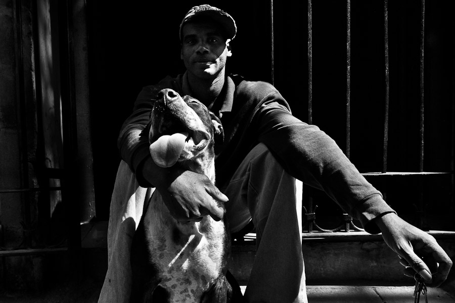 A Cuban man poses for a picture with his amstaff dog during a sunny morning in Havana, Cuba.